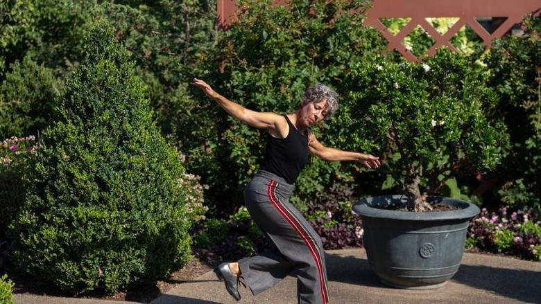 Woman tap dancing among trees